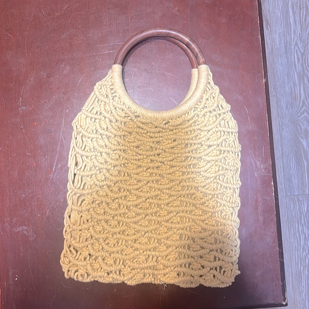 Hand bag with wood handles and a mesh tan fabric